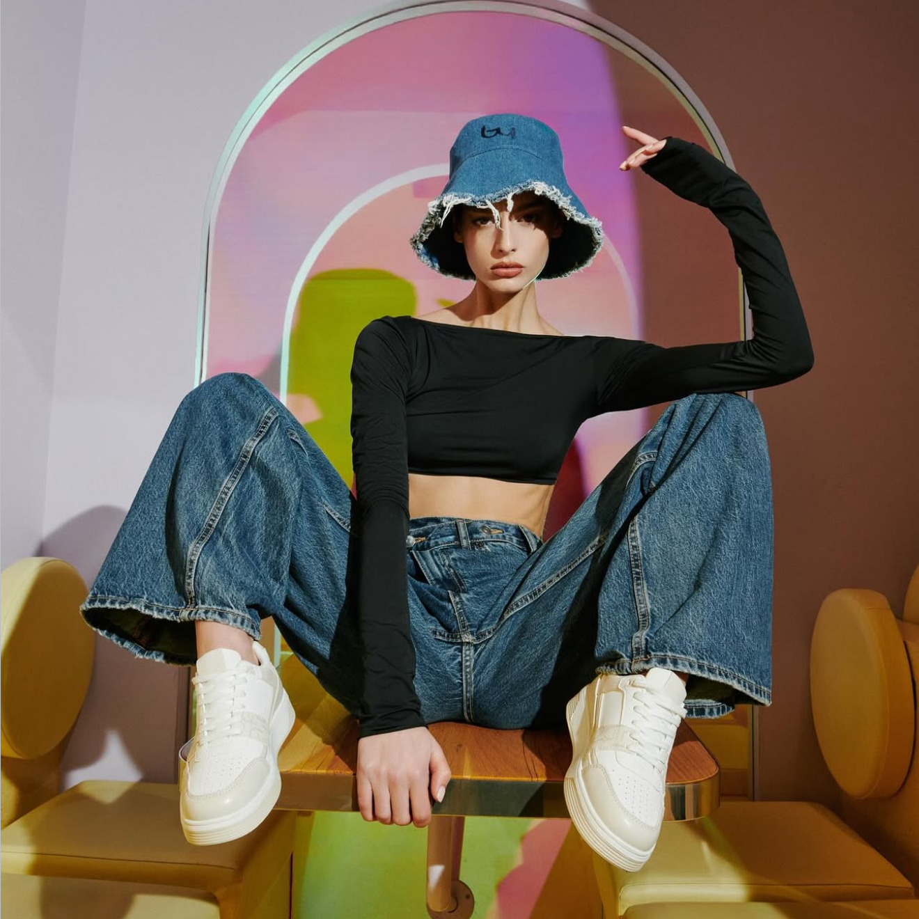 Person sitting on a colorful chair with a geometric background
