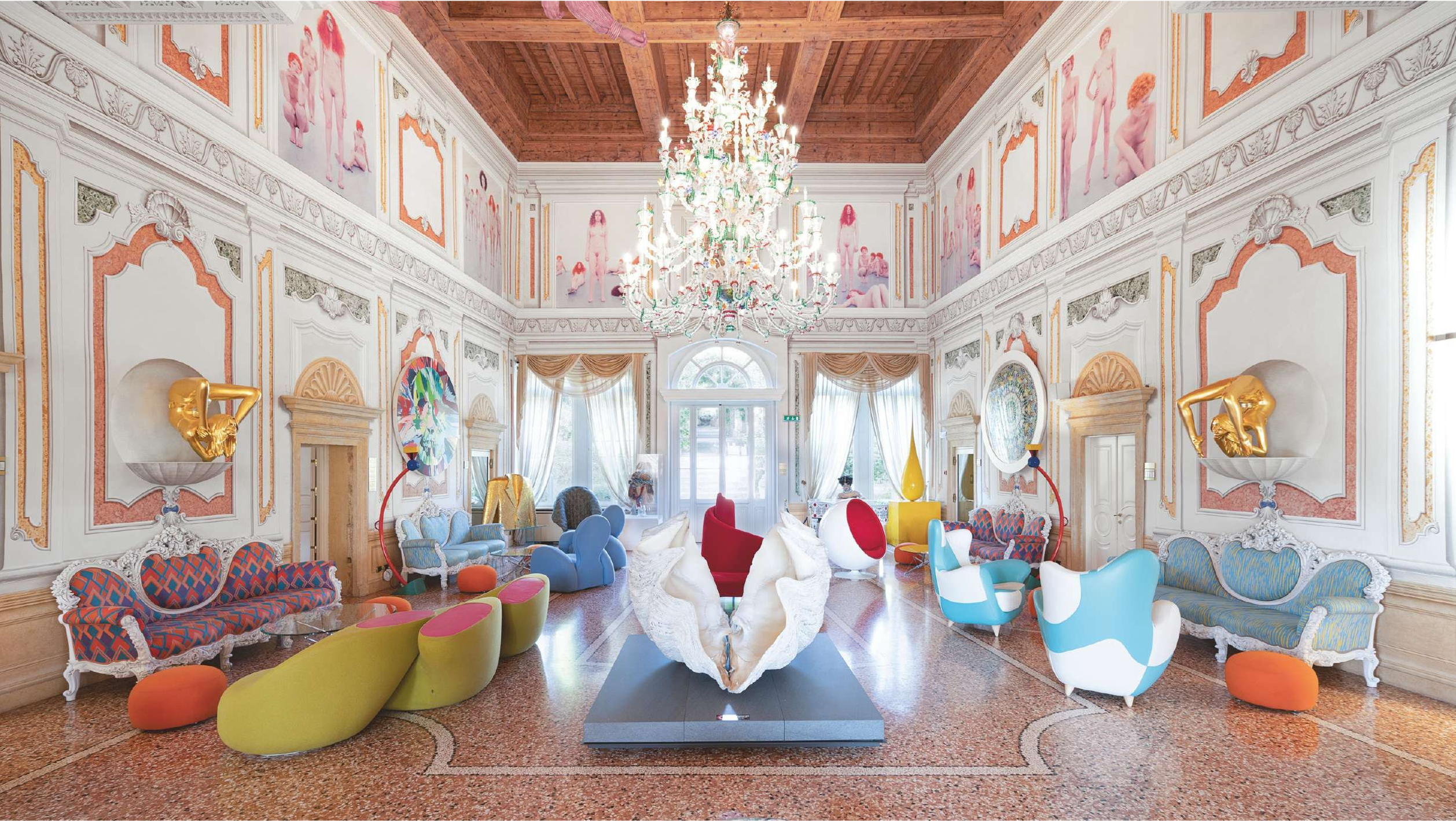 Luxurious interior design with colorful furniture and a chandelier in an ornate room.