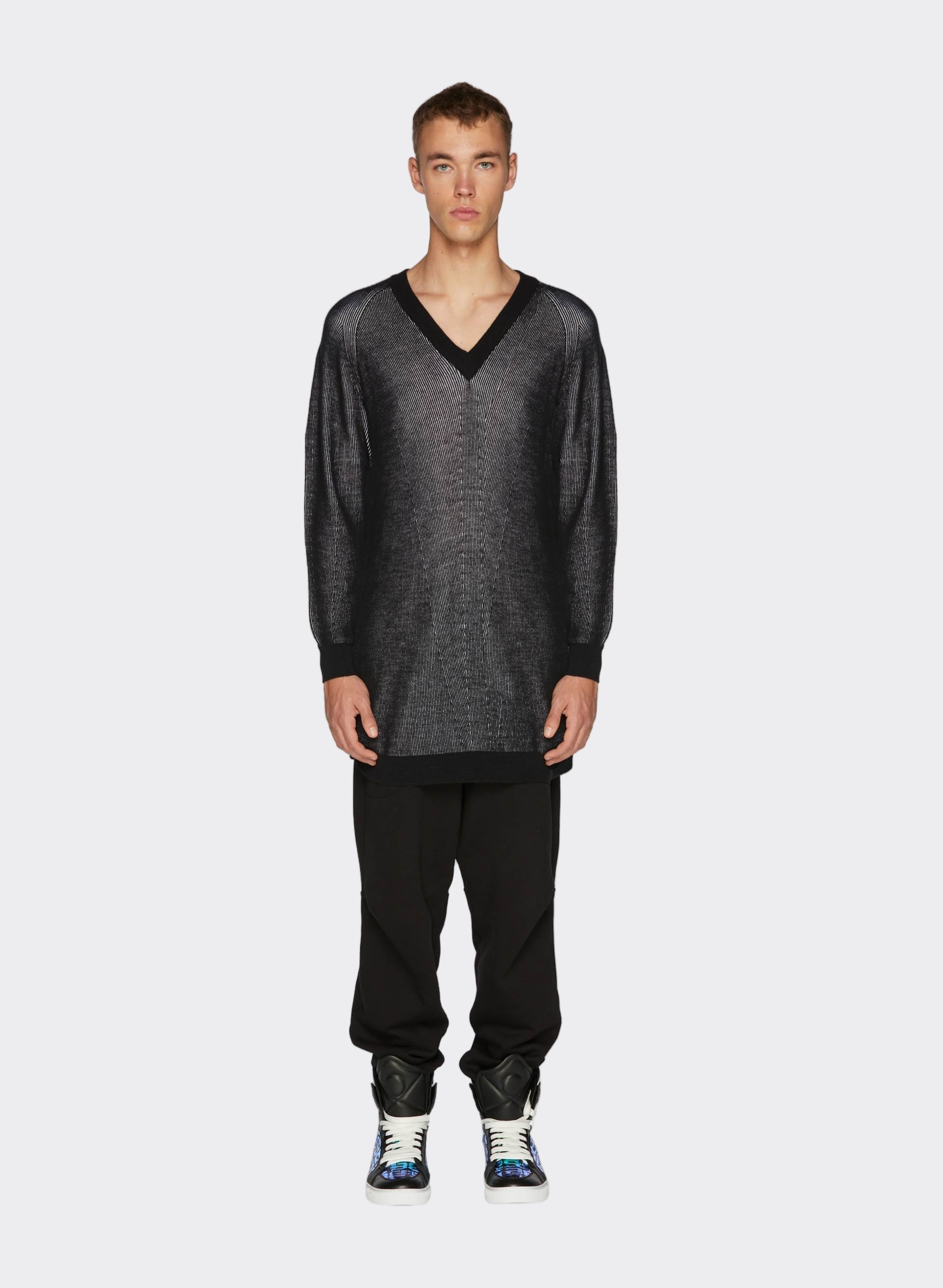 Long-sleeve black Knit Lines Maxi Jumper with a V-neck, paired with relaxed black trousers and stylish 3D Logo Iridescent Sneakers